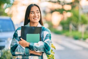 A university student carrying books on campus
